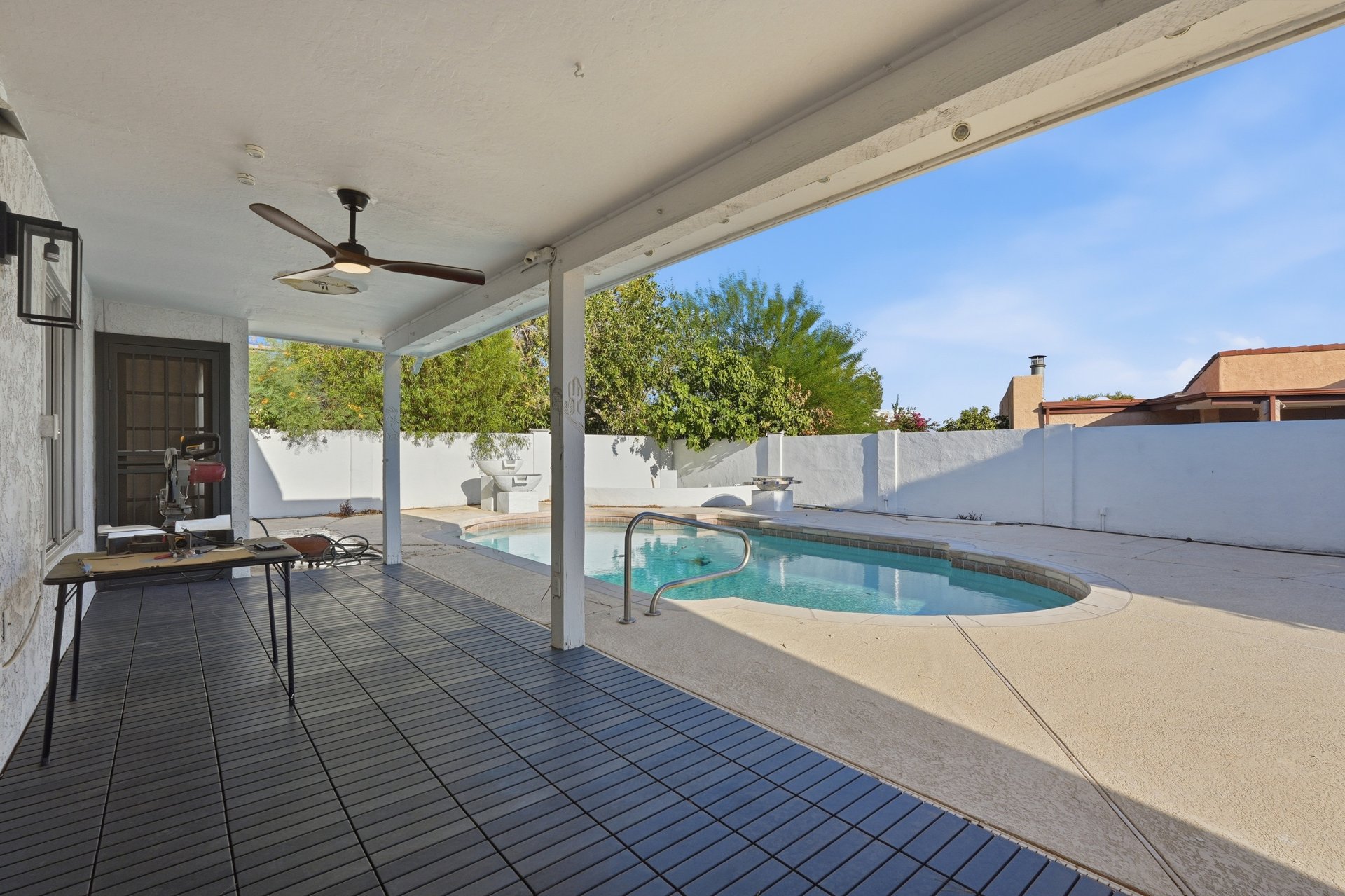 Covered patio with ceiling fan overlooking the pool