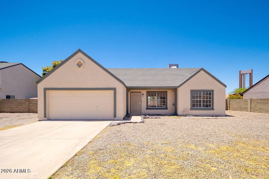Single story home with a two car garage and desert front yard