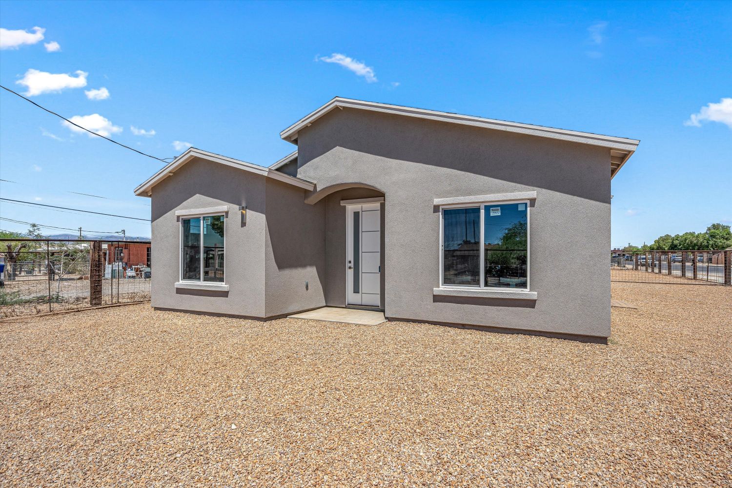 New construction single story home with a gravel yard