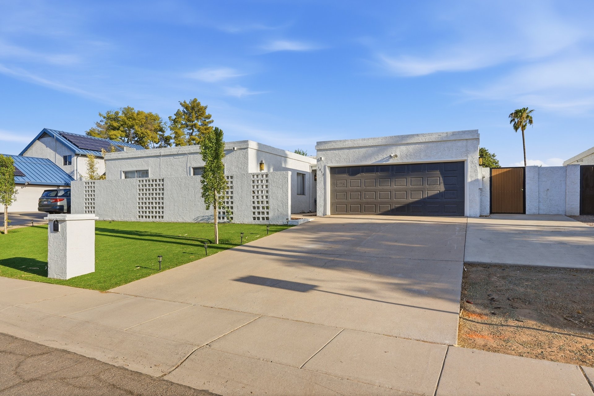 Front exterior with two car garage, block screen wall and lawn